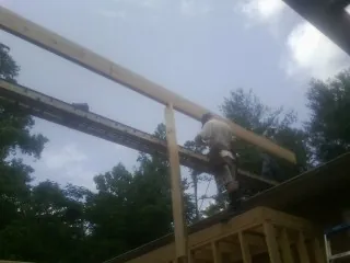 Carpenter setting a ridge beam over a new addition frame — Ice Dam Removal by Roofing Brothers in Emmaus